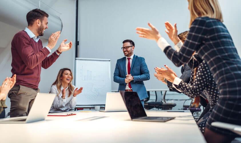 a group of people clapping in a meeting