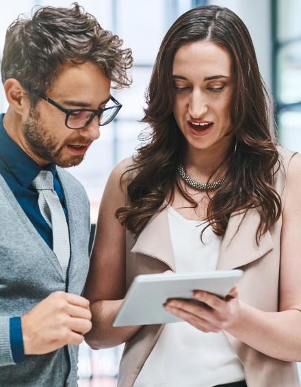 a man and woman looking at a tablet